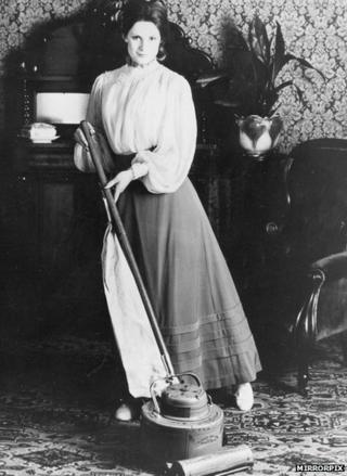 Woman using a vacuum cleaner in the 1920s