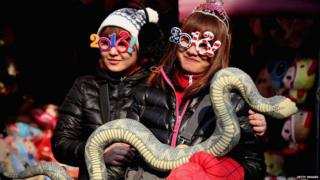 Girls hold snake.