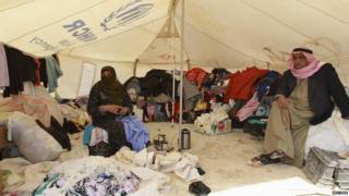 Refugees working on a second hand clothes stall in the camp