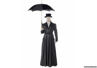 Black costume with a long coat and a black traditional looking umberella