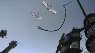 Two birds flying past a factory
