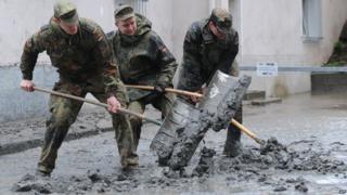 Soldiers shovel mud from the streets of Passau, Germany, on 4 June 2013