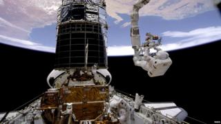 Astronauts repairing the Hubble Space Telescope