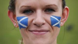 Woman with Scottish flag face paint.