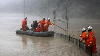 This picture taken on 9 July 2013 shows rescuers looking for victims as heavy flood waters sweep through Beichuan in south-west China's Sichuan province