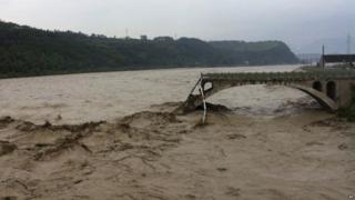 In this image taken by mobile phone camera, what remains of the Qinglian bridge that was swept away by heaving flood waters is seen in the city of Jiangyou in Sichuan on 9 July 2013