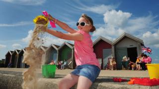 Girl playing with sand at Blyth beach in Northumberland