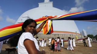 A Buddhist flag is held up high outside a temple in Anuradhapura, Sri Lanka.