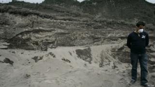 Man stood in ash on a volcano site