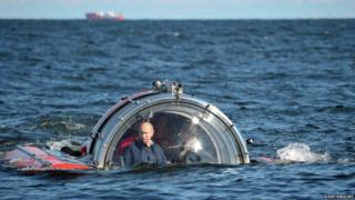 Vladimir Putin in a round mini-submarine type sea-craft.