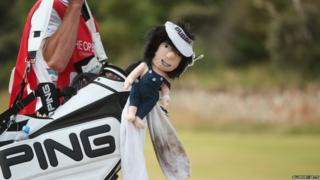 Bubba Watson walking with golf clubs.
