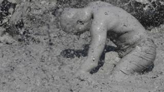 Tourist covered in mud at a festival