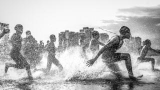National Geographic Traveler Photo Contest Grand Prize winner Wagner Araujo's image "Dig Me River" shows boys running into the Rio Negro river in Brazil.