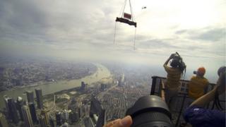 The final piece of steel for a tower in China is lowered into place.