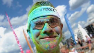 A man covered in coloured flour after a colour run in Germany.