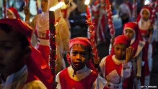 Children carry torches as Muslims parade on the streets ahead of Eid Al-Fitr