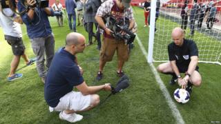 Journalists huddled around referee showing how the GDS system will work.