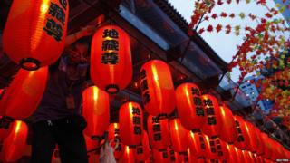 A man hangs up Chinese lanterns