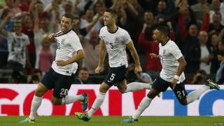 England's Rickie Lambert celebrates scoring against Scotland with teammates Gary Cahill and Alex Oxlade-Chamberlain during their international friendly match at Wembley Stadium in London.
