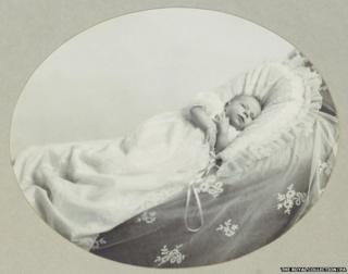 Previously unpublished family photograph issued by the Royal Collection of Queen Elizabeth II in her cot aged five weeks in 1926.