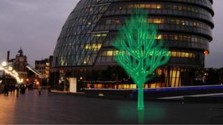 A luminous green tree in a city street