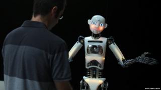 A humanoid robot greets a human
