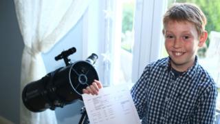 Monty poses with a telescope and his GCSE results