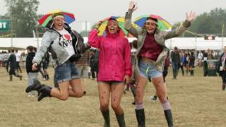 Three girls jumping in the rain