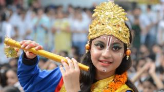 An Indian pupil dressed as the Hindu god Krishna poses on the eve of the Janmashtami festival at a school in Amritsar
