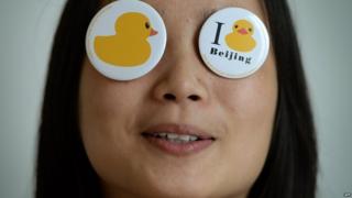 A Chinese girl poses with "Rubber Duck" badges after a press conference on August 28, 2013 to announce its imminent arrival in Beijing