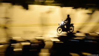 A man drives a moped in a street of Maldives's capital Male