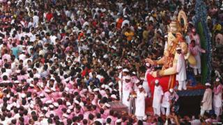 Devotees carry an idol of Hindu elephant god Ganesh, the deity of prosperity, during a procession through the streets