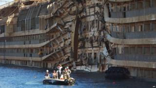 Salvage workers photograph parts of the Costa Concordia