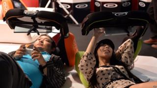 Visitors lay on pillows to play the videogame console and tablet holder Goron