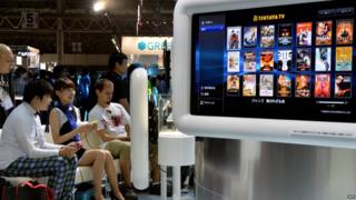 Visitors play PS Vita TV at the Tokyo Game Show