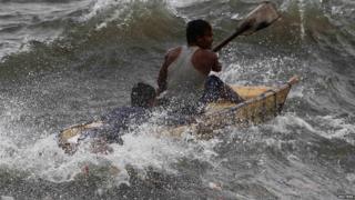 A man and a boy sit inside a makeshift raft