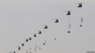 helicopters with soldiers hanging from them