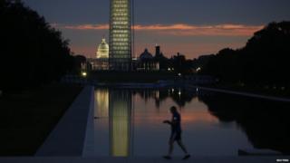An early morning jogger is pictured at the Lincoln Memorial reflecting pool at sunrise in Washington