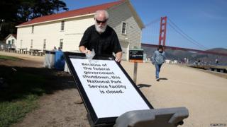 National Park Service worker Michael Faw posts a sign announcing the closure of a Park Service facility at Crissy Field