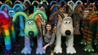 Dani Marlborough from Gromit Unleashed poses for a photograph among some of the giant Gromit sculptures