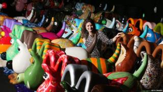 A lady in the middle of the colourful Gromit models