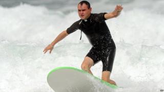 French Catholic priest Rene-Sebastien Fournie surfs at a beach in Bidart, southwestern France, on September 3, 2013