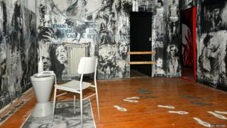 living room with a montage of faces inside tower block art project Tour 13 in Paris
