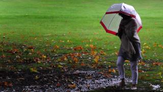 A woman braves the rain at Rufford Abbey, Ollerton, Nottinghamshire.