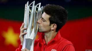 Novak Djokovic of Serbia poses for photographers with the winner"s trophy