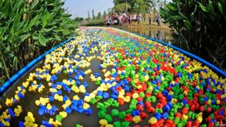 Small rubber ducks are released on a river during a donation drive in Shenzhen, Guangdong province, China