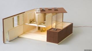 Dolls house made of wood and Perspex with gold bedding and chair
