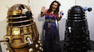 Fan dressed as Tardis poses with Daleks