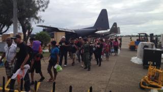 People walking off military planes