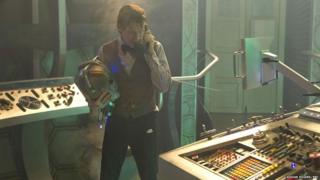The Doctor in the Tardis holding a Cyberman's head?